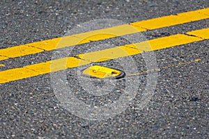 Raised yellow pavement marker separates opposing traffic lanes photo