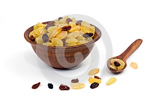 Raisins in a clay plate wooden spoon near