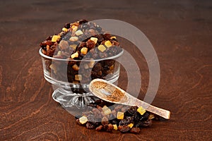 Raisins currants and sultanas with mixed candied peel in a glass bowl with wood spoon
