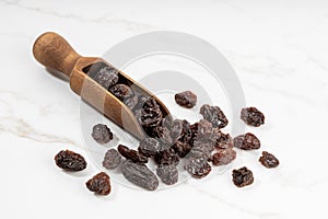 Raisins and scoop isolated on White marble