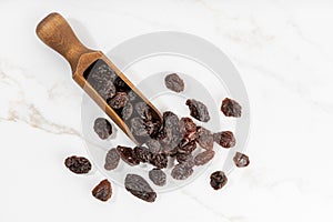 Raisins and scoop isolated on White marble