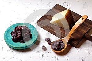 Raisins on a wooden plate and in a spoon and cheese photo