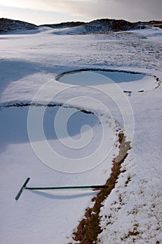 Rakes in bunkers on a snow covered golf course