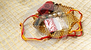 Rakhi thread in gold holder with tika & rice