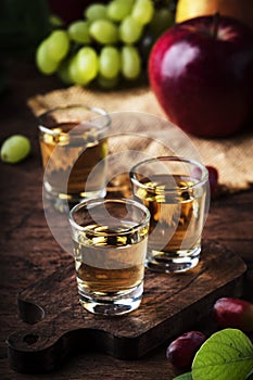 Rakija, raki or rakia - Balkan hard alcoholic drink or brandy from fermented fruits, old wooden table, still life, copy space