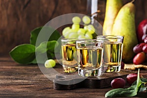 Rakija, raki or rakia - Balkan strong alcoholic drink brandy type based on fermented fruits, vintage wooden table, still life in