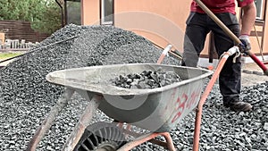 Raking the gravel into the areas to try and even it out at the start of the hardscaping. Closeup of gravel work for landscaping an
