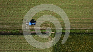 Raking hay with a double wheel rake tractor on a sunny day aerial view