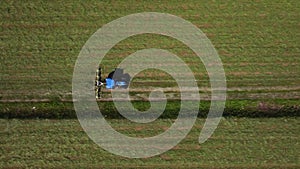 Raking hay with a double wheel rake tractor on a sunny day aerial view