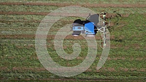 Raking hay with a double wheel rake tractor on a sunny day aerial view