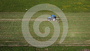 Raking hay with a double wheel rake tractor on a sunny day aerial view