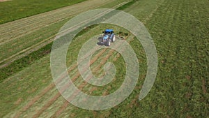 Raking hay with a double wheel rake tractor on a sunny day aerial view