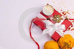 Raksha Bandhan Festival â€“ Close view of elegant Rakhi, sweets, blue gift box, and Indian currency notes with kumkum and rice