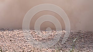 Rally car splashing dust and gravel in race track