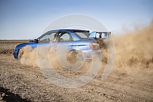 a rally sport car driving on the drit gravel race, fast speed with mud splash