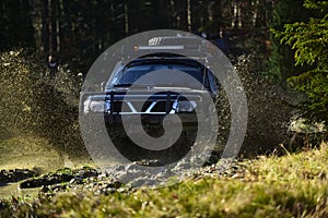 Rallying, competition and four wheel drive concept. Offroad race on fall nature background. Motor racing in autumn