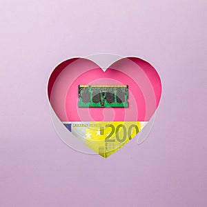 The ram memory and the two hundred euro banknote are in a pink heart on a purple background. Minimal concept of money, love and