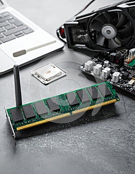 Wi-Fi card, RAM chip and computer motherboard in gray table, shutdown