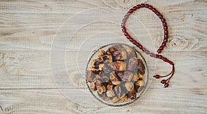 Ramadan dates and rosary on the table. Selective focus.