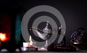 Ramadan food and drinks concept. Ramadan Lantern with arabian lamp, wood rosary, tea, dates fruit and lighting on a wooden table