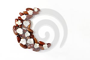 Ramadan, iftar desktop composition. Dried date fruit arranged in moon shape,decorated with Hydrangea flowers on white