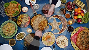 Ramadan iftar Eid. Muslim family has dinner at home. Table with traditional food. Eid al-Fitr celebrations