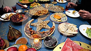 Ramadan iftar Eid. Muslim family has dinner at home. Table with traditional food. Eid al-Fitr celebrations