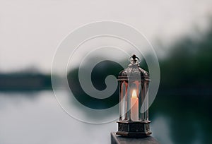 Ramadan Kareem, Arabic lantern with burning candle with blurry natural background.Image for Festive greeting card,invitation for