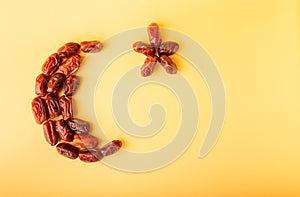 Ramadan kareem with dried dates arranged in shape of crescent moon