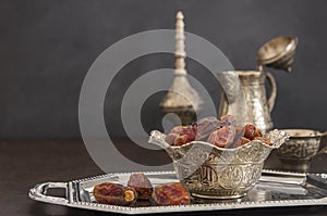 Ramadan kareem with dried dates and authentic metal zamzam water carafe photo