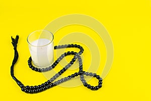 Ramadan Kareem Festival. Candle and rosary on yellow background. Happy ramadan hoilday. Copy space