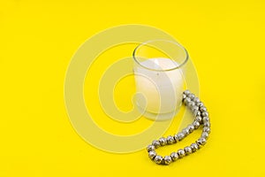 Ramadan Kareem Festival. Candle and rosary on yellow background. Happy ramadan hoilday. Copy space