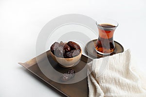 Ramadan Kareem Festival, Dates on wooden bowl with cup of black tea and rosary on white  background