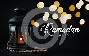 Ramadan Kareem Greeting Typography Beautiful Bokeh. Ramadan Candle Lantern with Wooden Prayer Beads photo