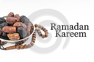 RAMADAN KAREEM text with Dates or kurma fruits and rosary beads or Tasbih on white background.