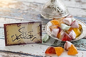 Ramadan kerim text in arabic on vintage table with candies