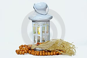 Ramadan lantern (fanoos) with an Islamic rosary around it isolated on a white background with a copy space for typing