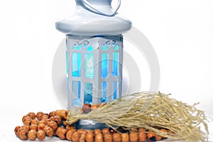 Ramadan lantern (fanoos) with an Islamic rosary around it isolated on a white background with a copy space for typing