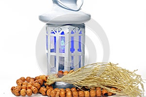 Ramadan lantern (fanoos) with an Islamic rosary around it isolated on a white background with a copy space for typing