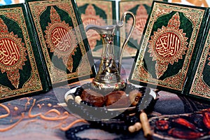 Ramadan month background, selective focus of dates fruit, rosary, holy Quran books and a brass jug