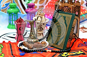 Ramadan month background, selective focus of Ramadan lanterns fanous, dates fruit, rosary, holy Quran and a brass jug