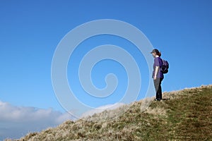 Rambler on skyline on fellside footpath, Cumbria