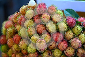 Rambutan exotic fruit of the lychee family on market in Saigon, Vietnam. Fresh lychees stapled on market in Ho-Chi-Minh-City