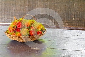 Rambutans fruit in basket on a wood desk background