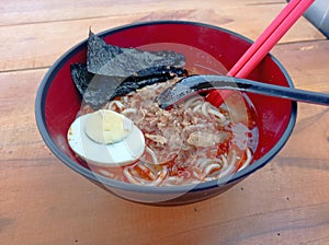 ramen in a bowl.
brown wood background