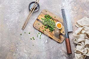 Ramen eggs on wooden cuting board with knife, copy space