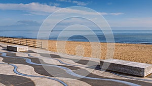 Ramsgate beach main sands and wave patterned concrete promenade  on a clear blue winter day