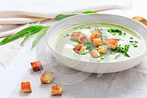 Ramson or bear leek soup with crouton and sour cream