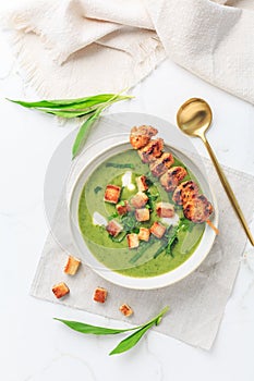 Ramson or bear leek soup with crouton, sour cream and turkey skewer