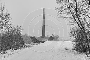 Rana hill in white storm snowy morning near Louny town with ruin chimney